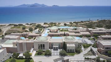 Ein Resort mit mehreren Gebäuden, einem Schwimmbad und Blick auf den Strand.
