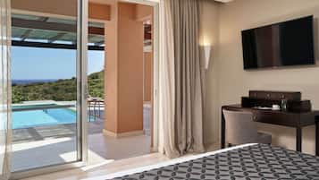 Ein Hotelzimmer mit Bett, Schreibtisch, Fernseher und Blick auf Pool und Landschaft.