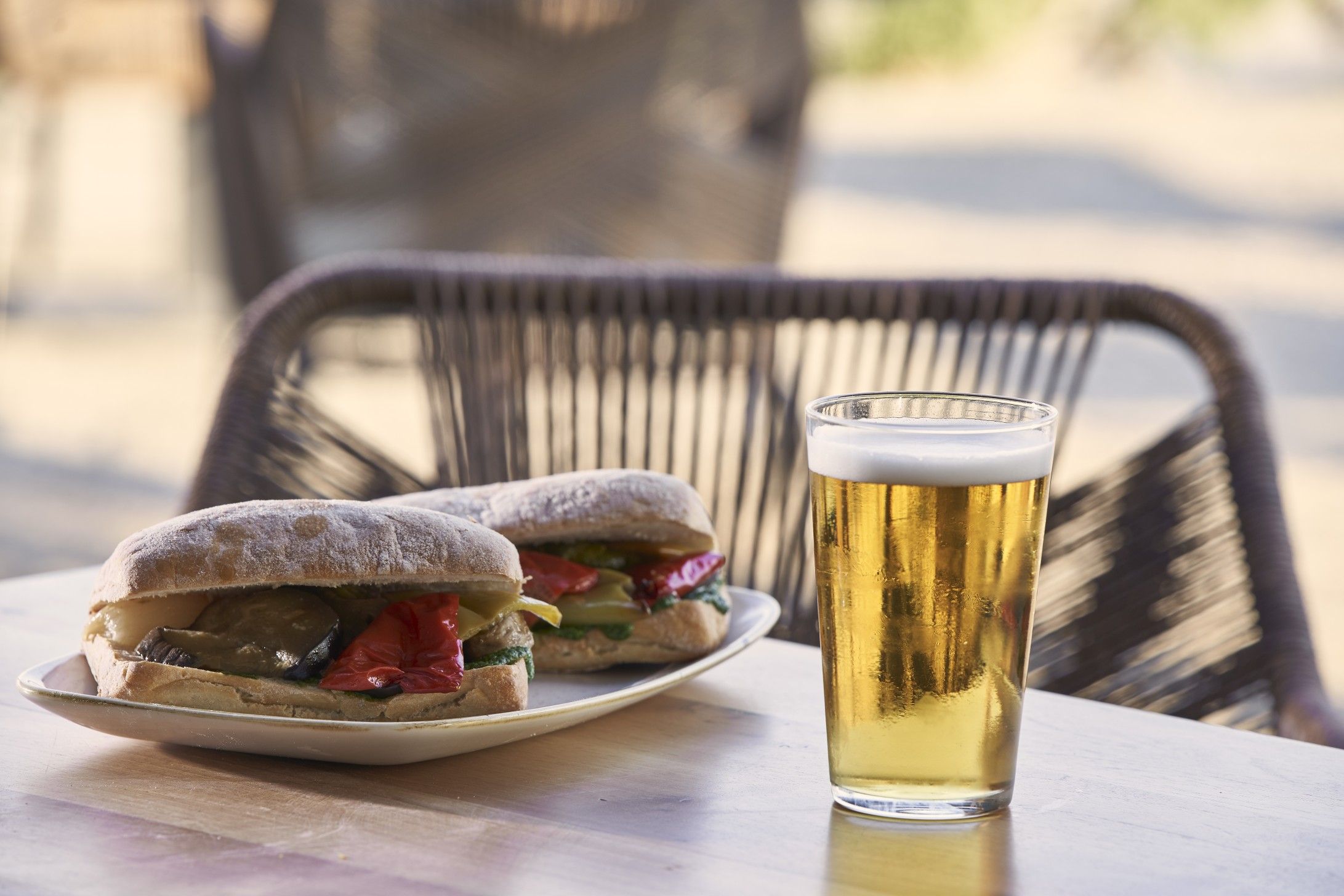 Un sandwich et un verre de bière sur une table.