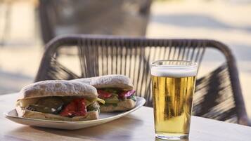 Un sandwich et un verre de bière sur une table.
