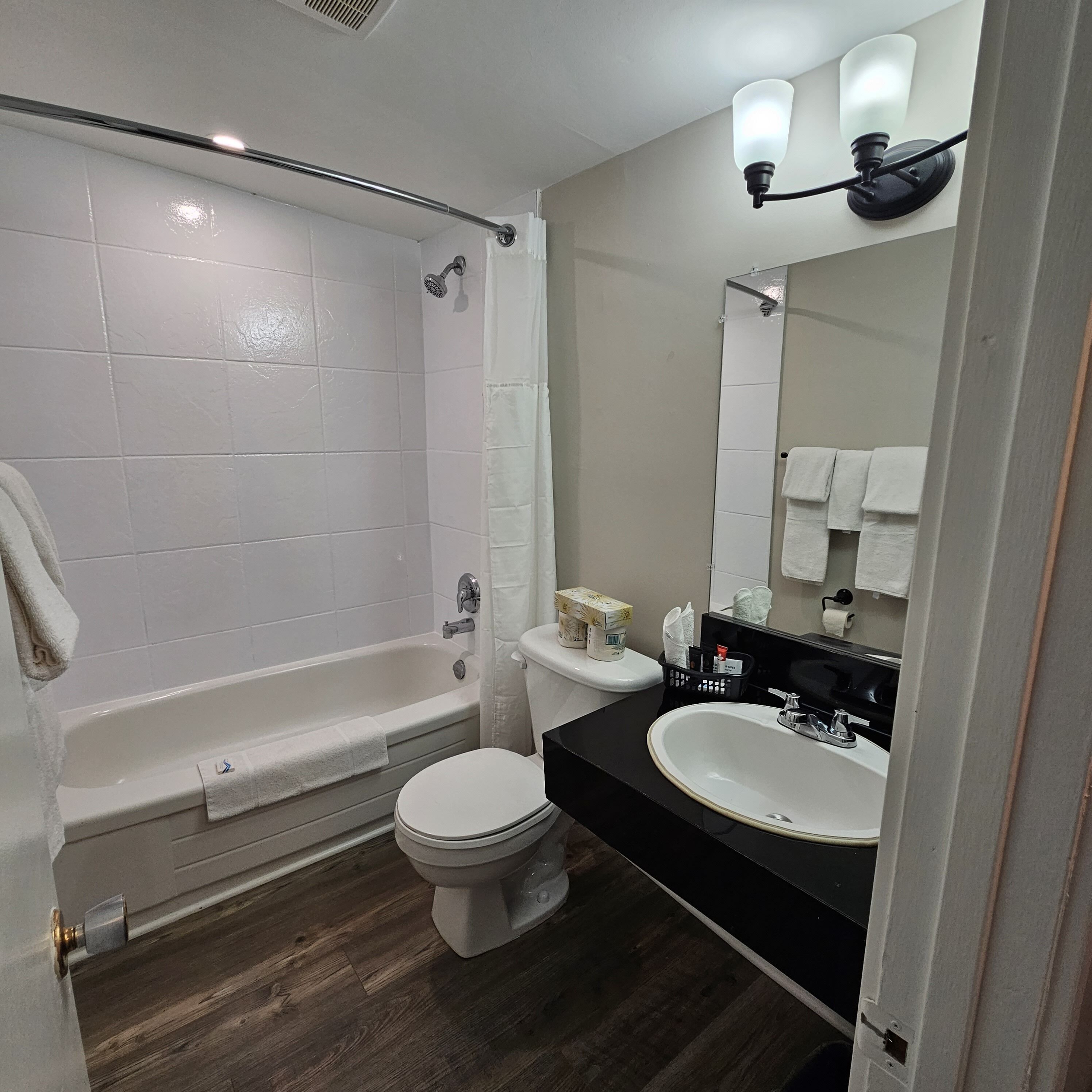 A modern bathroom with a bathtub, toilet, and sink.