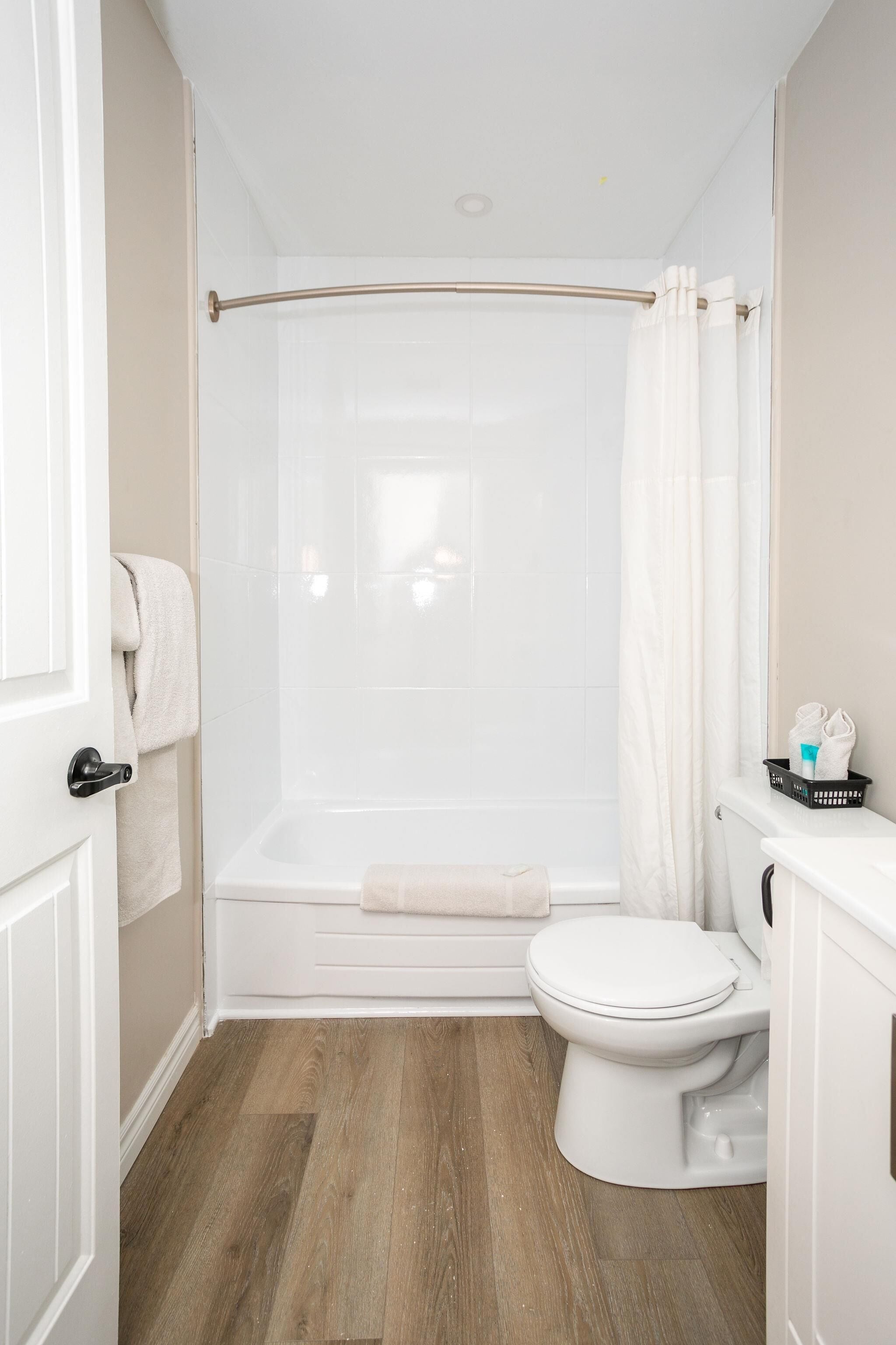 A bathroom with a shower, toilet, and a towel rack.