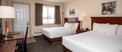 A hotel room with two beds, a desk, a chair, a lamp, a window with curtains, and a painting on the wall.