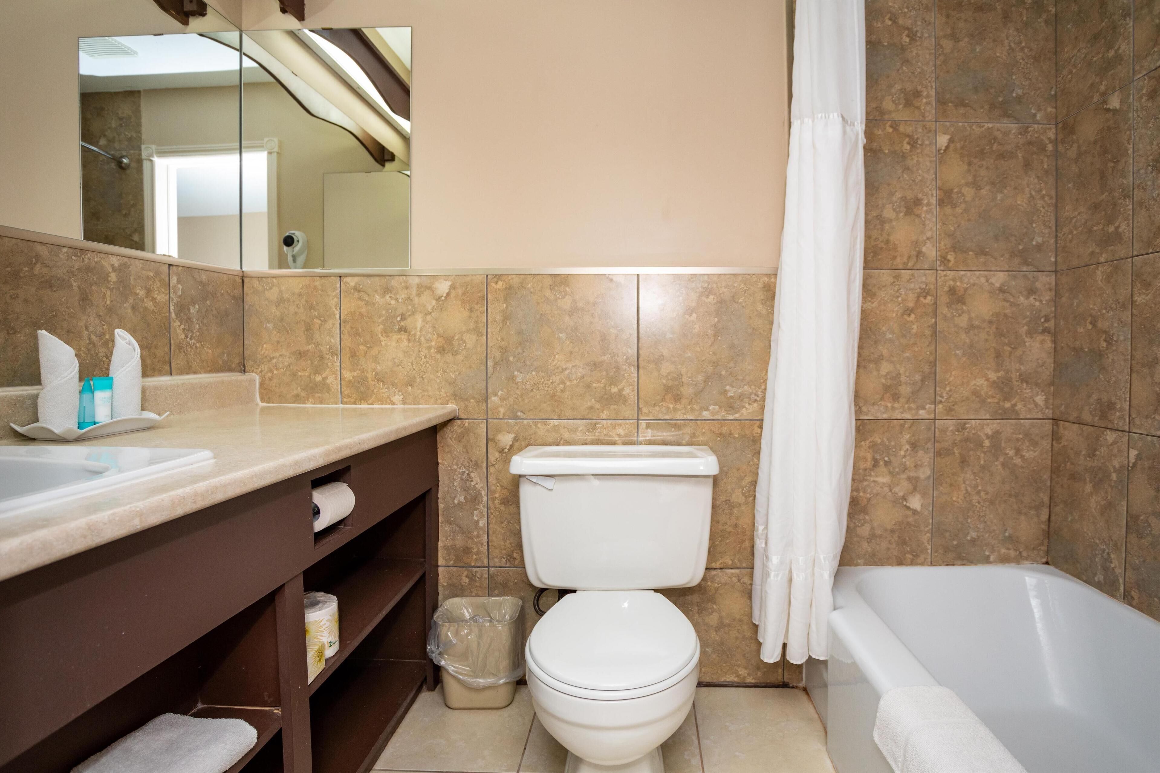Un baño con inodoro, lavamanos y bañera.