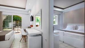 A modern hotel room with a bed, a desk, a chair, and a large window. - Gaia Royal Hotel (Kos)