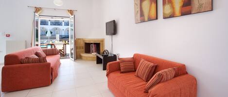 A modern living room with two sofas, a flat-screen TV, and artwork on the wall.