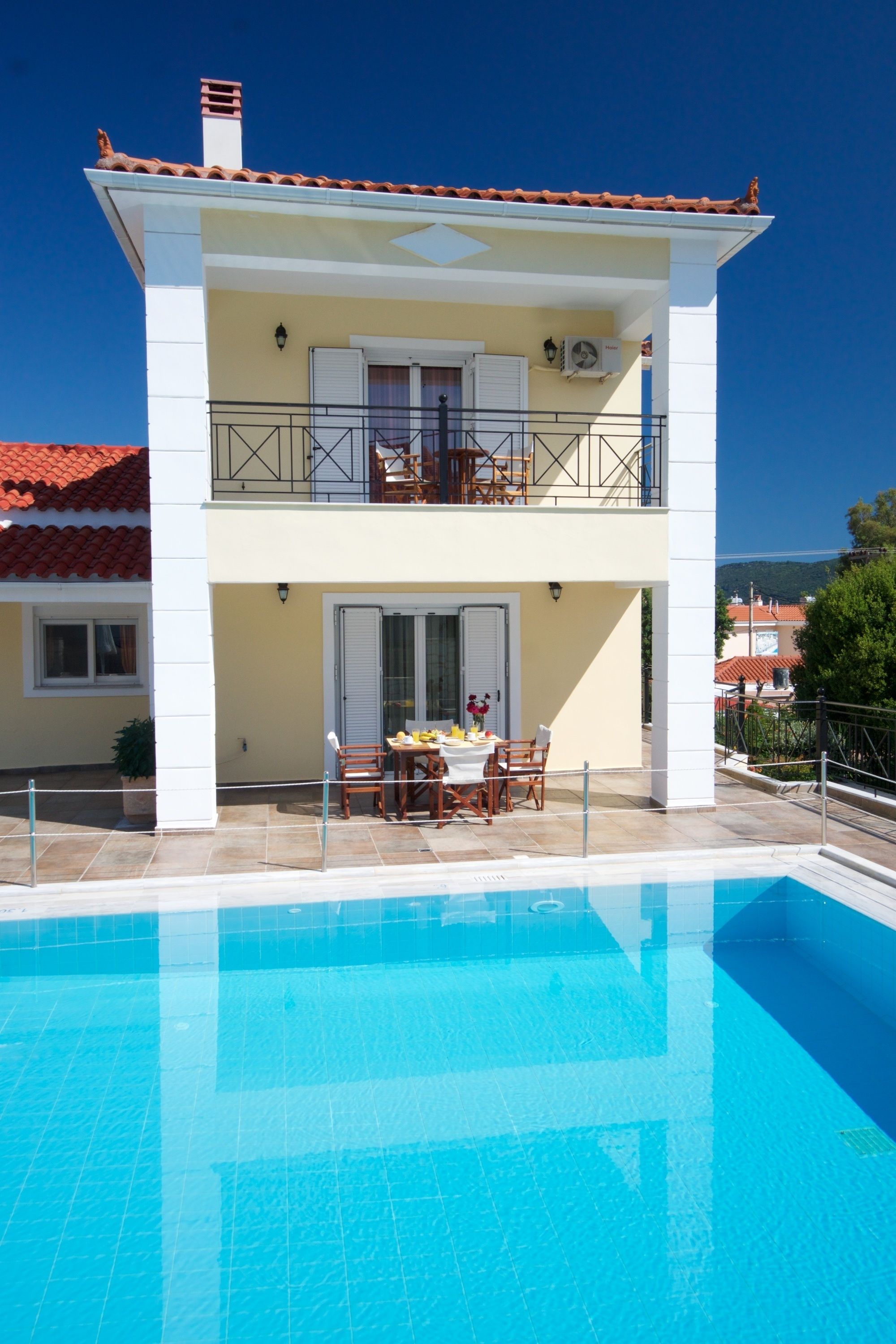 A two-story building with a swimming pool in front.