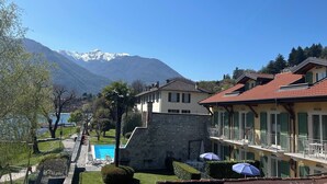 Un hotel con piscina, una pared de piedra y vistas a la montaña.