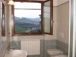 A bathroom with a window, a sink, and a toilet. - Enolocanda del Tufo - Guest House (Dogliani)