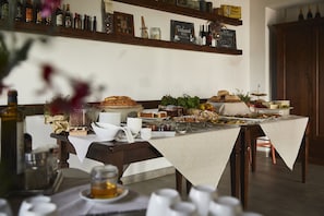 Enjoy a casual meal in this inviting dining area with a long table set for a meal, surrounded by rustic charm and a chalkboard menu.