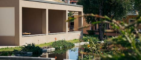 Un edificio moderno con amplios ventanales y un pequeño estanque en primer plano.