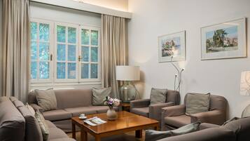 A modern living room with a sofa set, a coffee table, and two framed artworks on the wall.