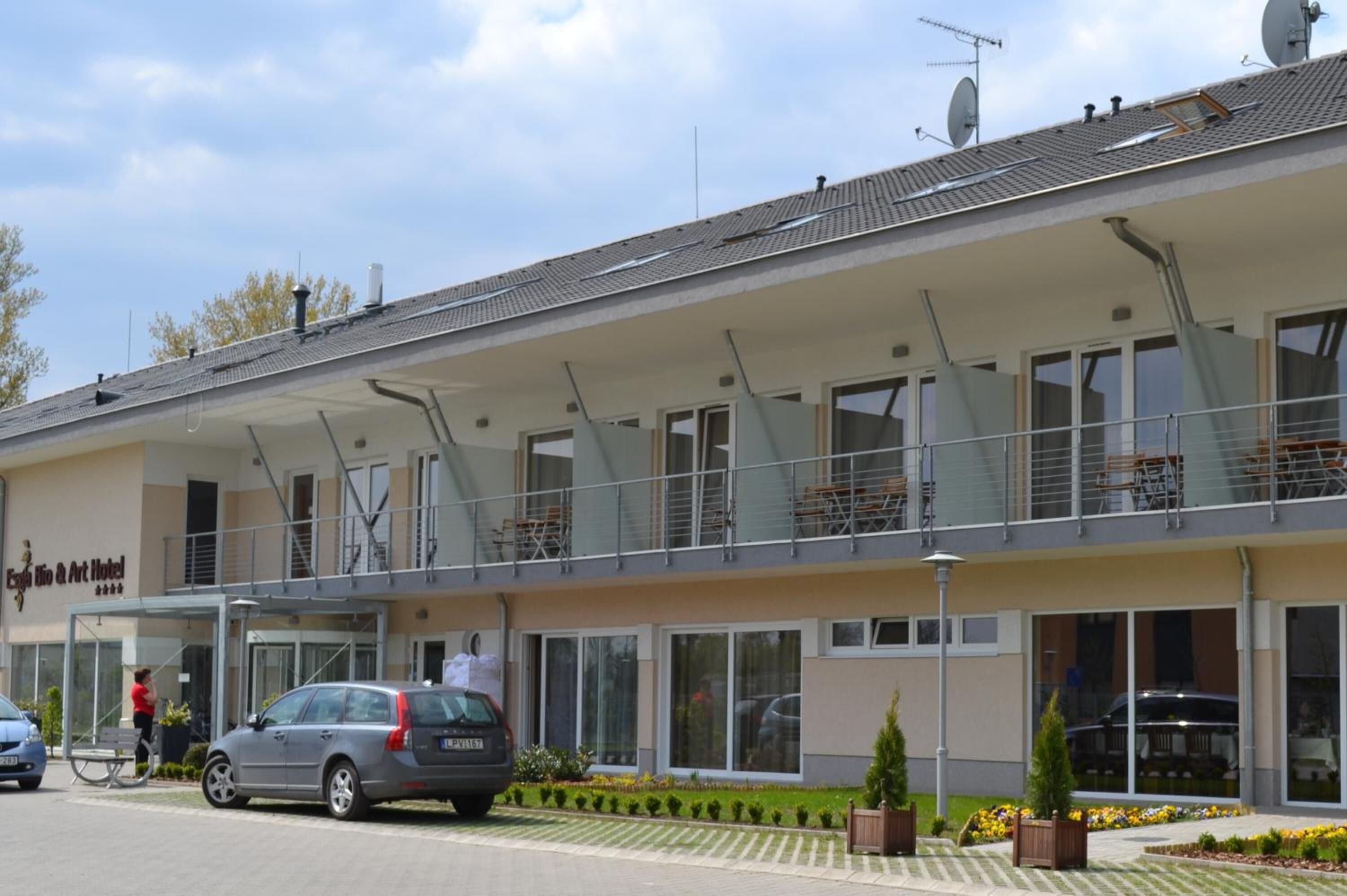 A two-story hotel with a covered outdoor seating area, large windows, and a sign reading "Hotel".