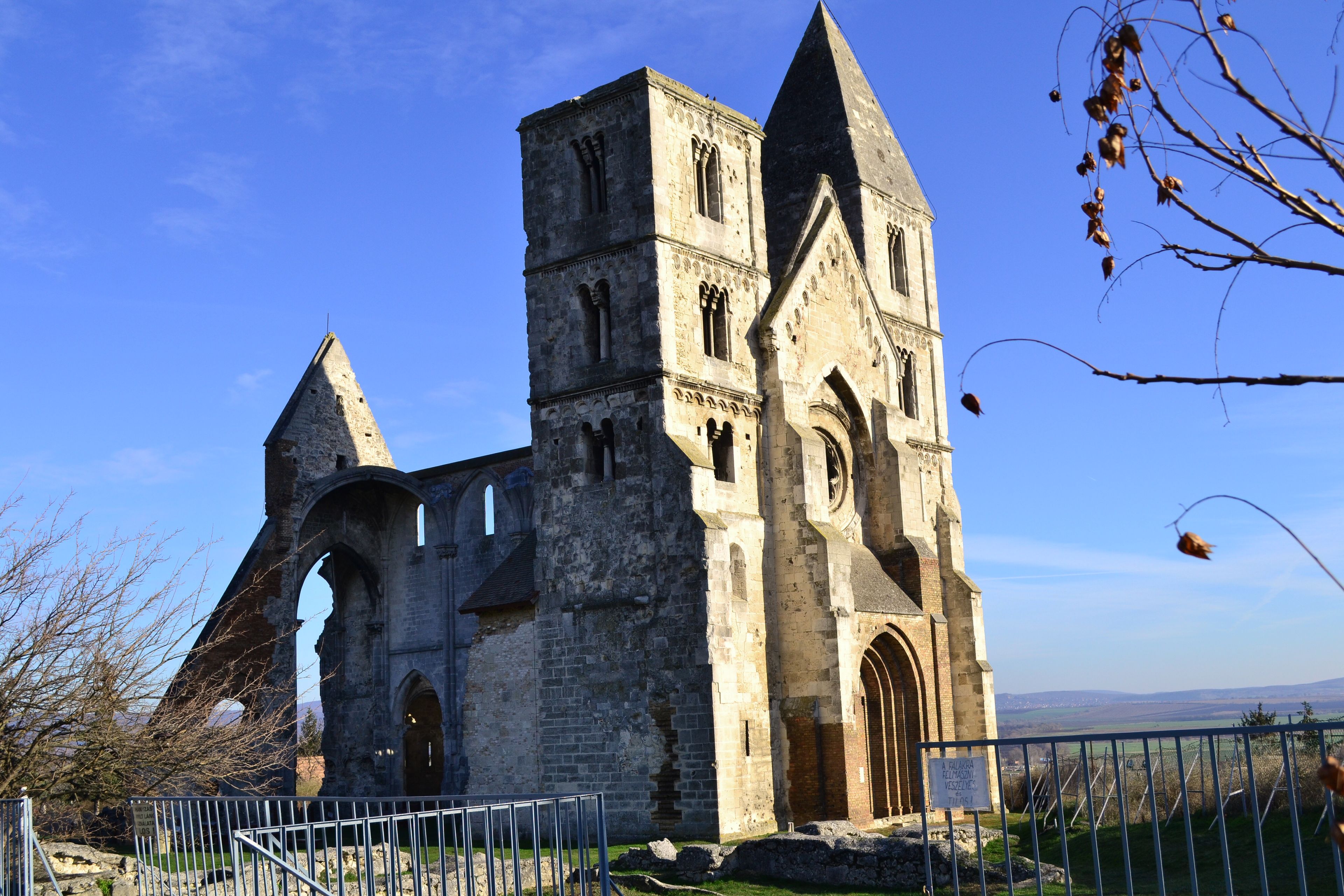 A historic stone church with a tall bell tower and arched windows.