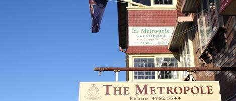 Un edificio con un letrero que dice 'The Metropole Guesthouse' y una bandera.