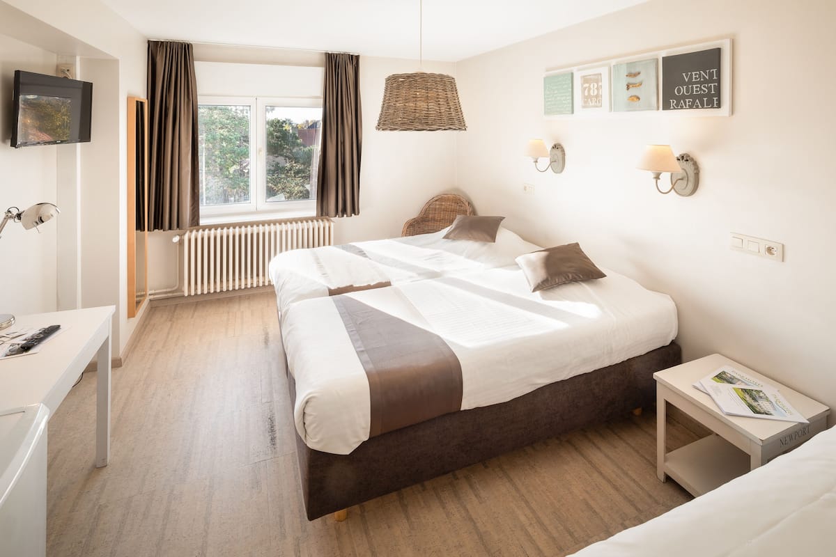 Ein modernes Schlafzimmer mit einem großen Bett, Nachttischen, einem Schreibtisch und einem Fenster mit Vorhängen.