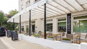 Un hôtel doté d’une terrasse extérieure, d’un patio couvert et d’un panneau indiquant les équipements et services proposés.