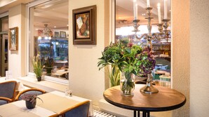 Un restaurant avec une table ronde, des chaises et un vase rempli de fleurs.