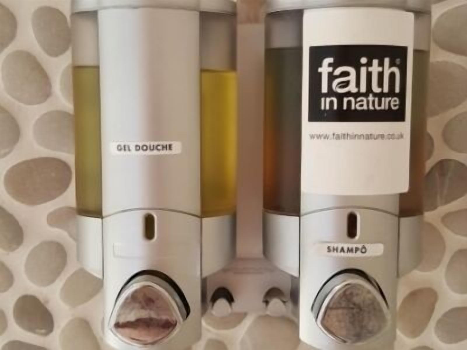 Two bottles of Faith in Nature products, one labeled 'Gel Douche' and the other 'Shampoo', displayed in a transparent case.