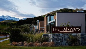 Un bâtiment moderne avec une enseigne indiquant : « THE FAIRWAYS, hébergement ».