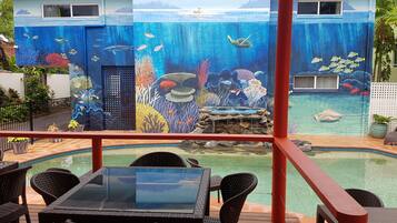 Un espace piscine agrémenté d’une fresque représentant un paysage sous-marin, avec des poissons et des coraux.