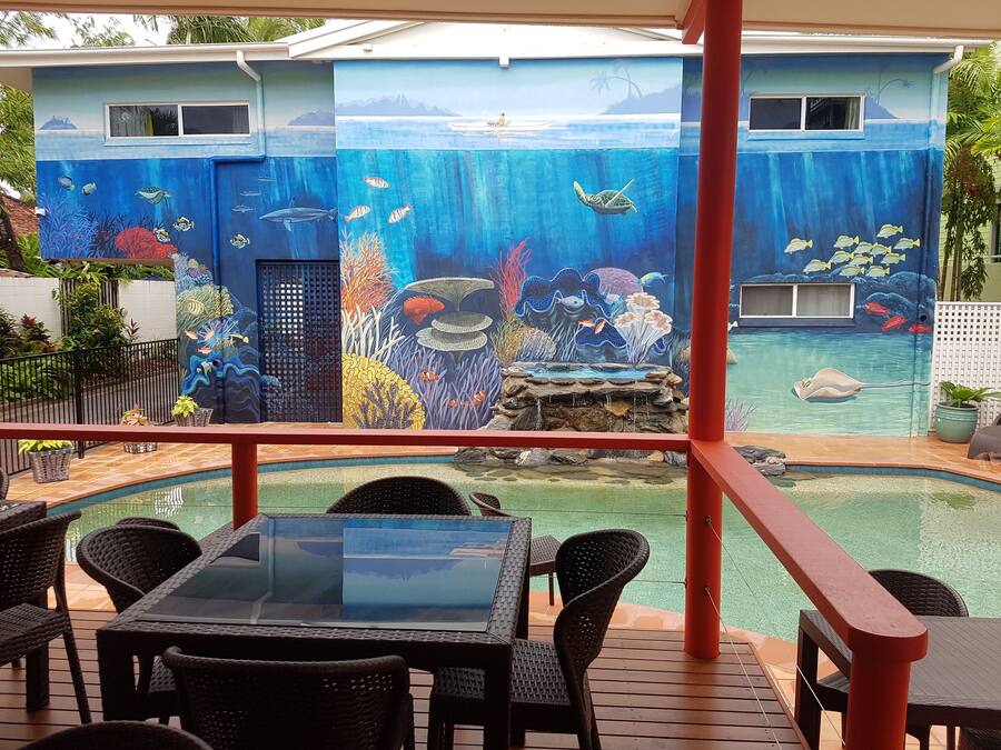 Un espace piscine agrémenté d’une fresque représentant un paysage sous-marin, avec des poissons et des coraux.