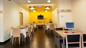 A dining area with tables and chairs, a television, and a coffee machine. - Hotel Residence Empedocle (Messina)