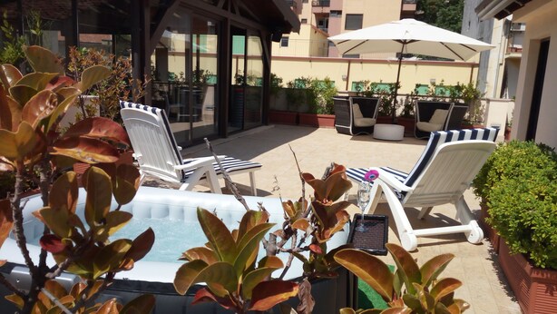 A poolside area with lounge chairs, a hot tub, and potted plants. - Hotel Residence Empedocle (Messina)
