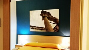 A hotel room with a bed, a nightstand, a lamp, and a framed picture on the wall. - Hotel Residence Empedocle (Messina)