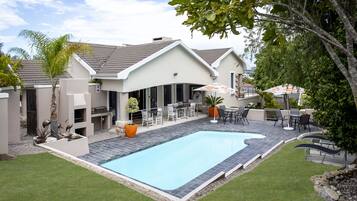 Piscine extérieure, parasols de plage, chaises longues