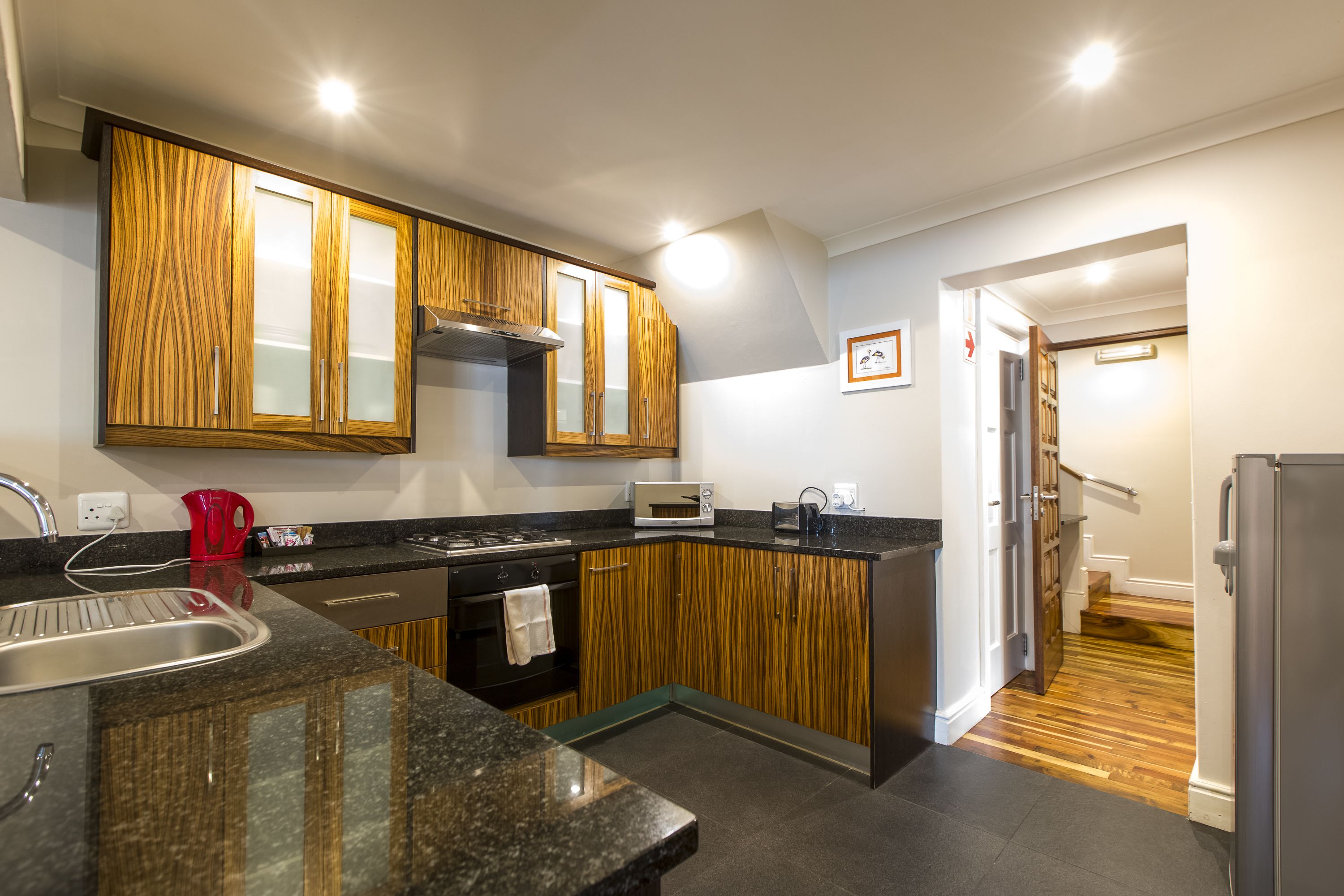 A modern kitchen with wooden cabinets, a stainless steel sink, and a built-in oven.