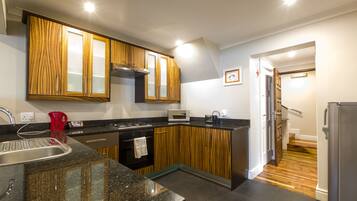 A modern kitchen with wooden cabinets, a stainless steel sink, and a built-in oven.