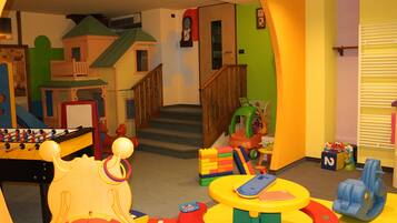 Kids can play and explore in this spacious playroom with a foosball table, playhouse, and building blocks.
