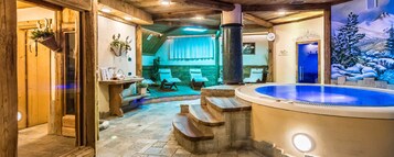 A spa area with a hot tub, wooden steps, and a mural of a snowy landscape.