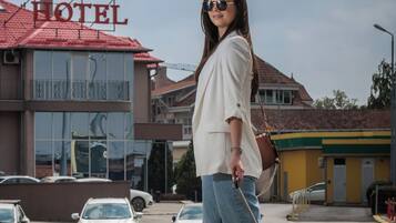 A woman walking past a building with a sign that reads "Eurogarni Hotel".