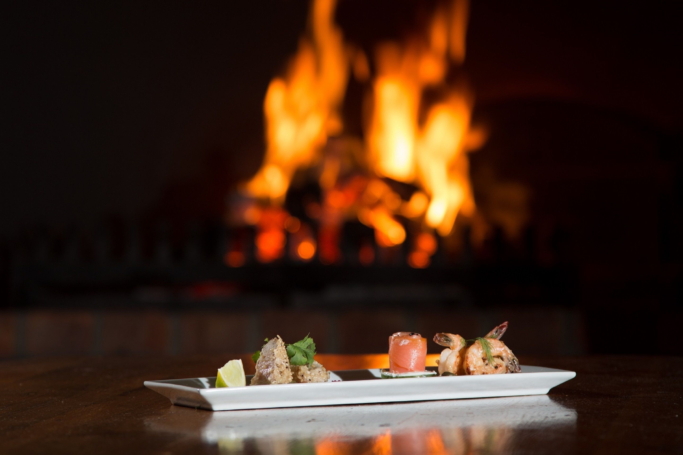 Un plato de comida con fuego al fondo.