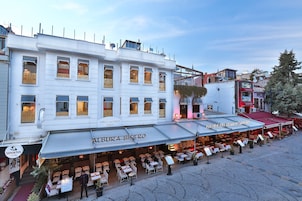 Un restaurante con terraza, un cartel que dice 'Al Buraq Al Kaisimah Restaurant' y una entrada visible al 'Senatus Hotel'.