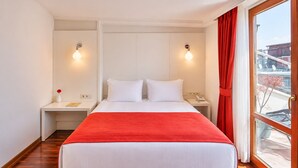 A hotel room with a bed, nightstands, a red throw, and a view through a window. - Senatus Hotel - Special Class (Istanbul)