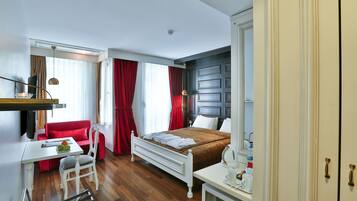 Ein Hotelzimmer mit Bett, Schreibtisch, Sessel und einer roten Couch.