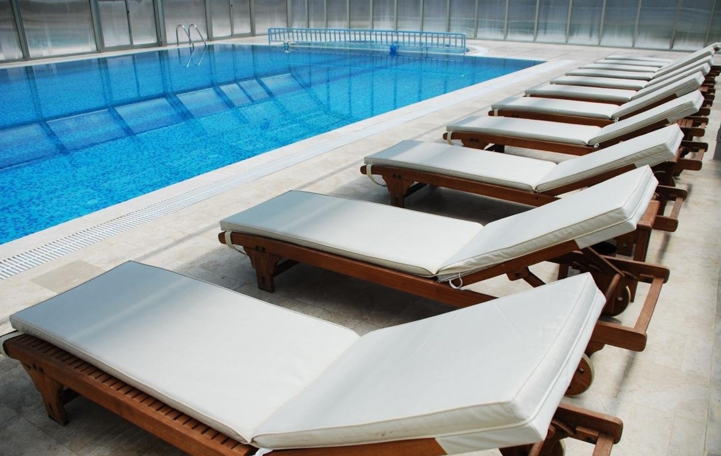 Una piscina con tumbonas dispuestas a lo largo del borde.