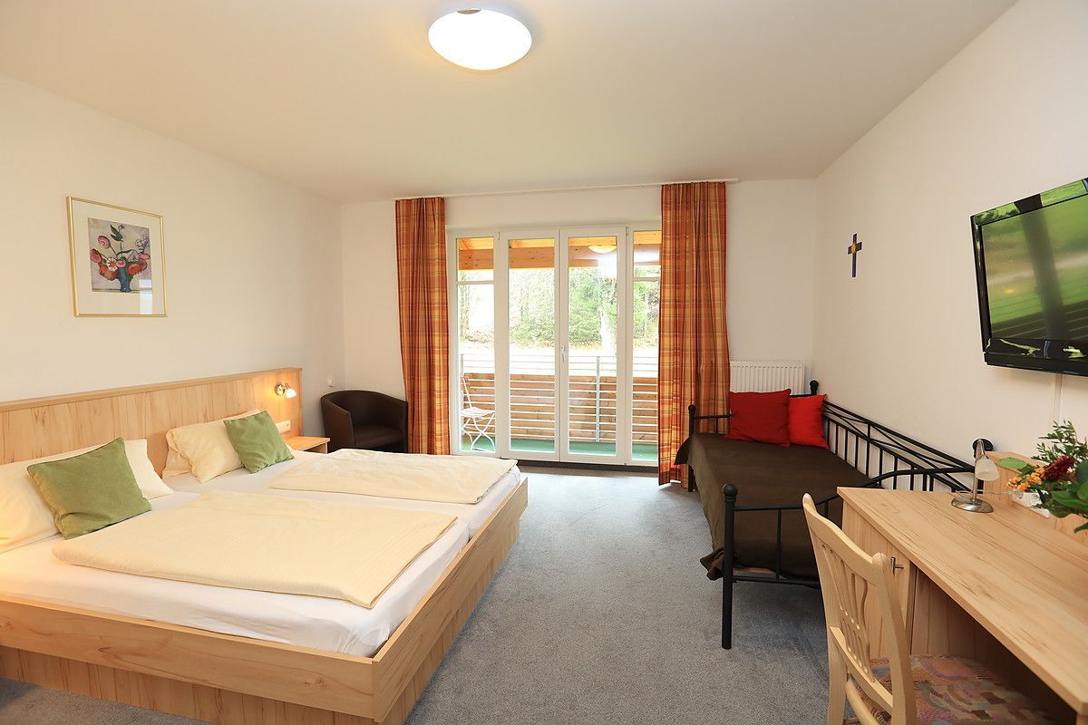 Une chambre à coucher avec un lit, un bureau et une télévision.