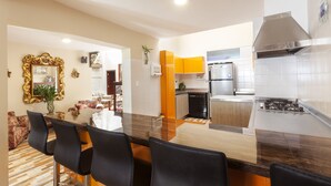 Een moderne keuken met een rvs afzuigkap, een vaatwasser en een koelkast.