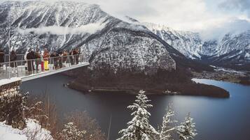A snow-covered mountain landscape with a bridge and a lake.