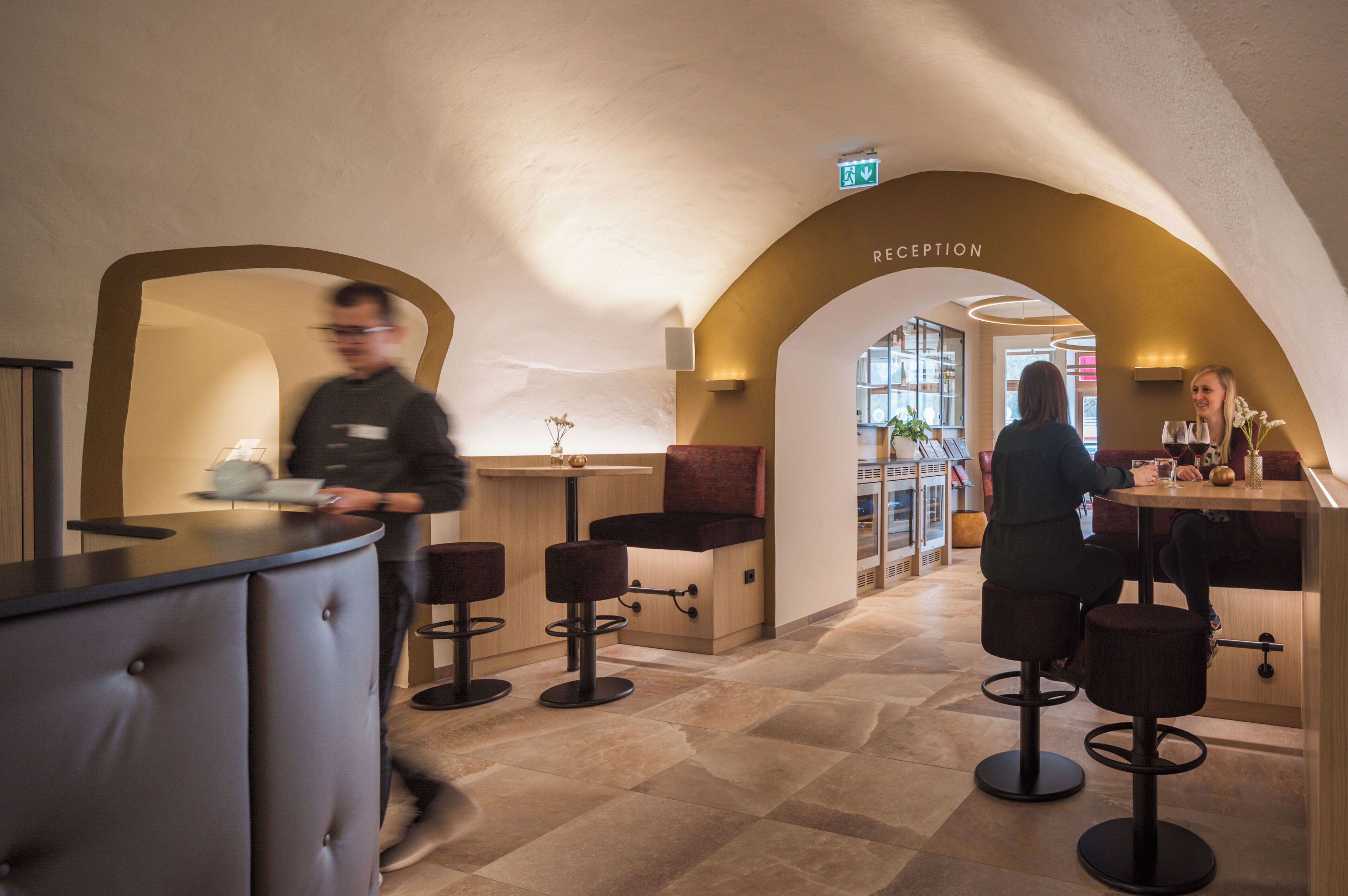 Un espace d’accueil au design moderne, comprenant un comptoir d’accueil, un espace salon et un panneau indiquant clairement la sortie.