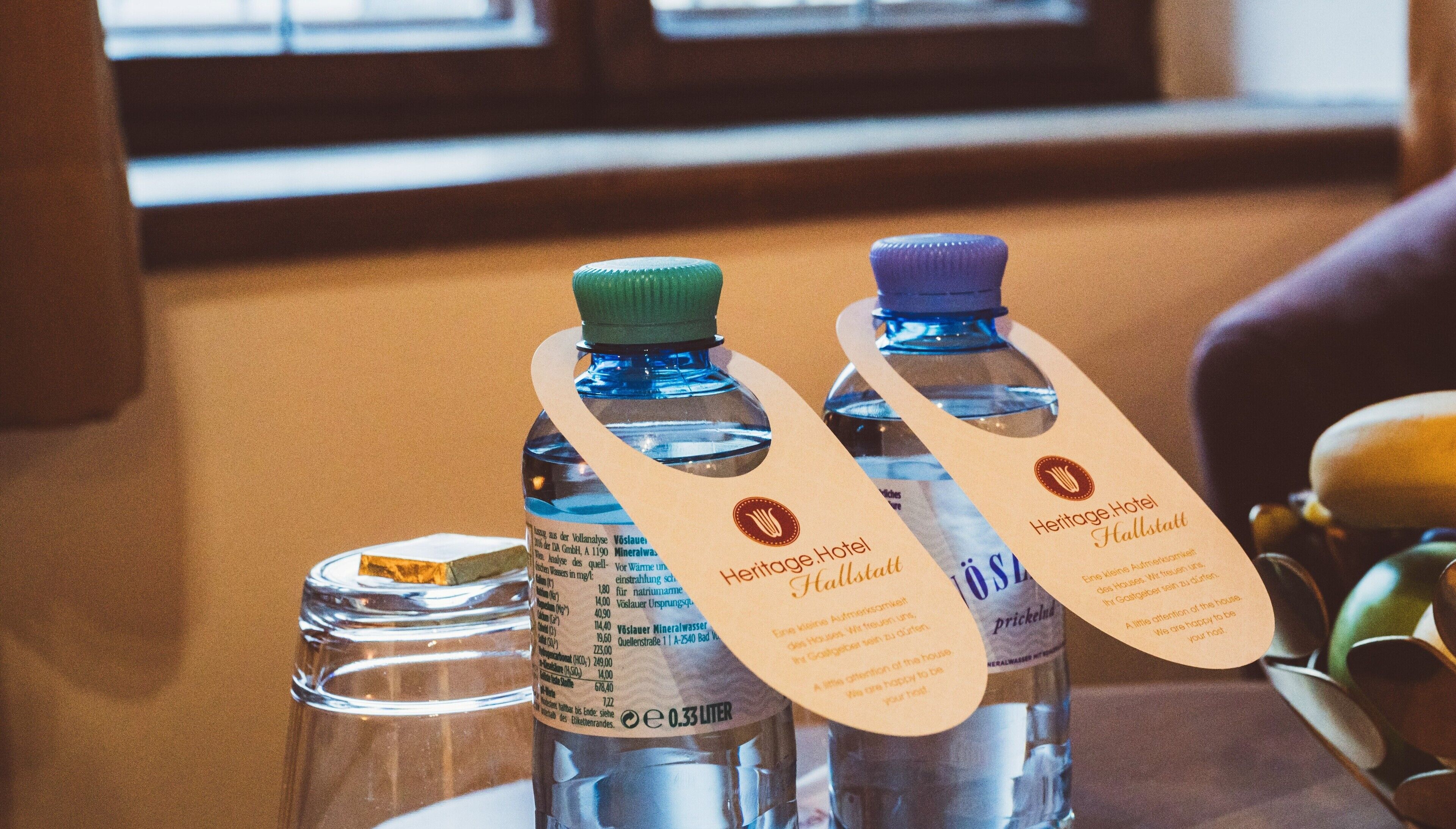 Two water bottles with labels and tags from Heritage Hotel Hallstatt.