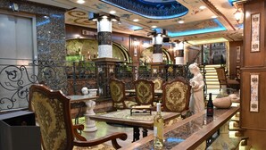 A bar area with ornate furniture, a statue, and a marble countertop. - Boris Palace Boutique Hotel & Winery (Plovdiv)