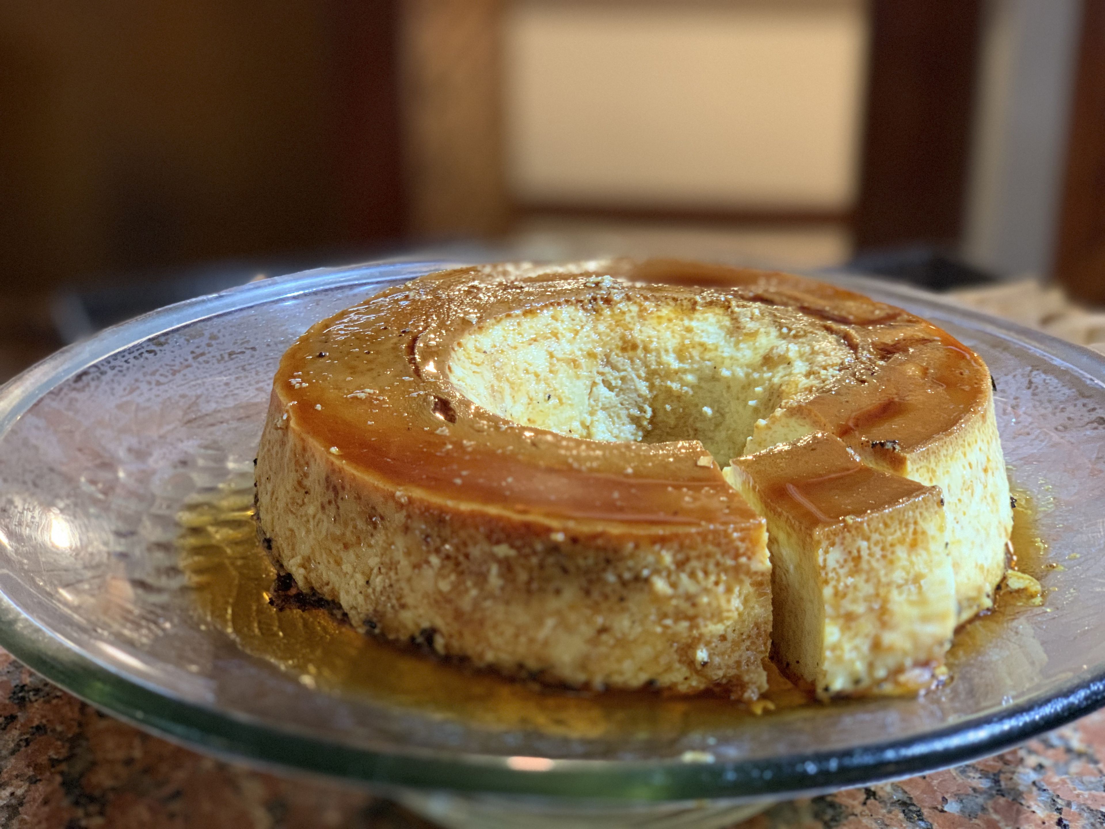 A caramel flan on a glass plate.