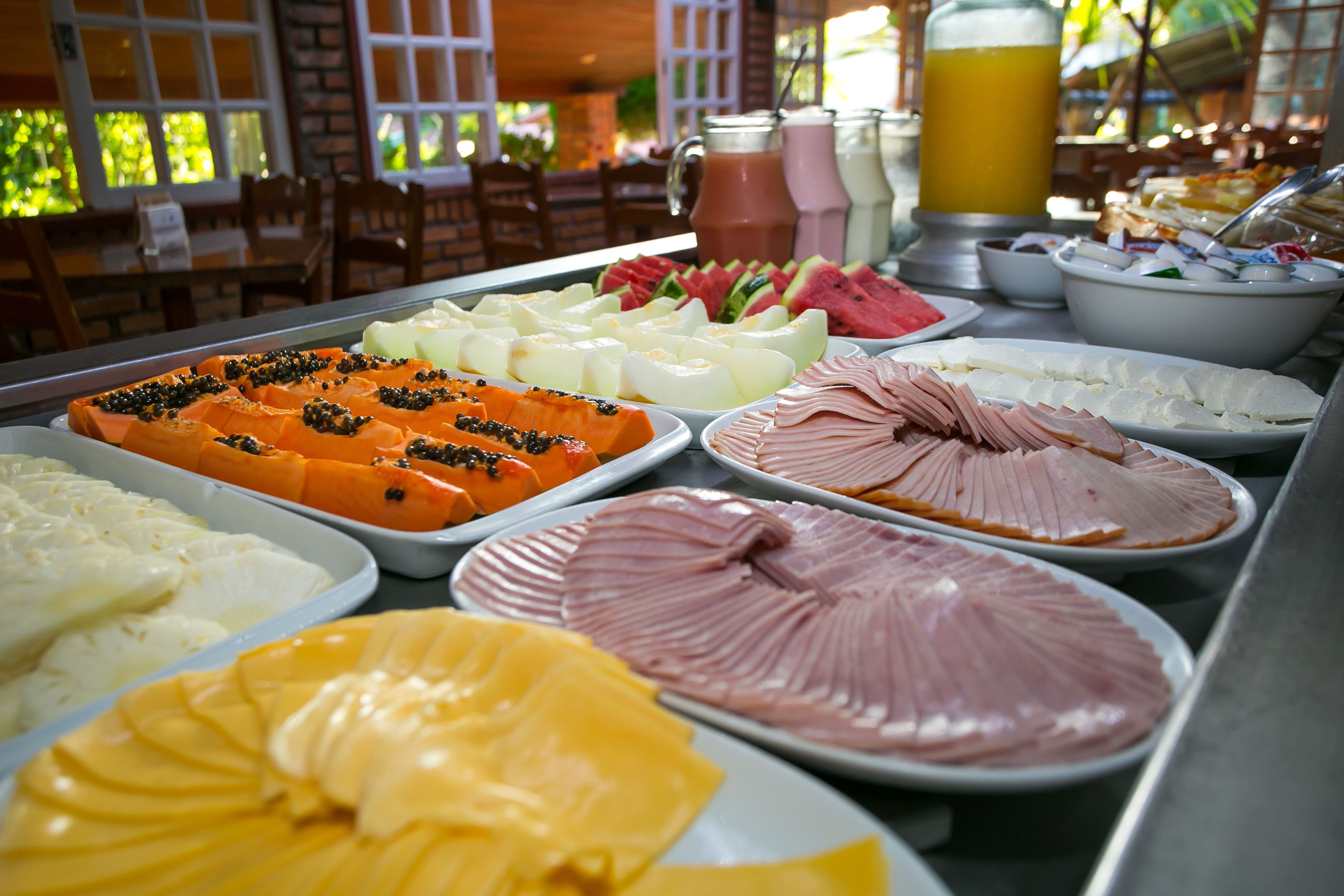 A buffet table with various food items including fruits, cheeses, and meats.