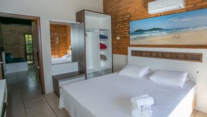 A hotel room with a bed, a wardrobe, a bathroom, and a beach view. - Hotel Sao Sebastiao Da Praia (Florianópolis)