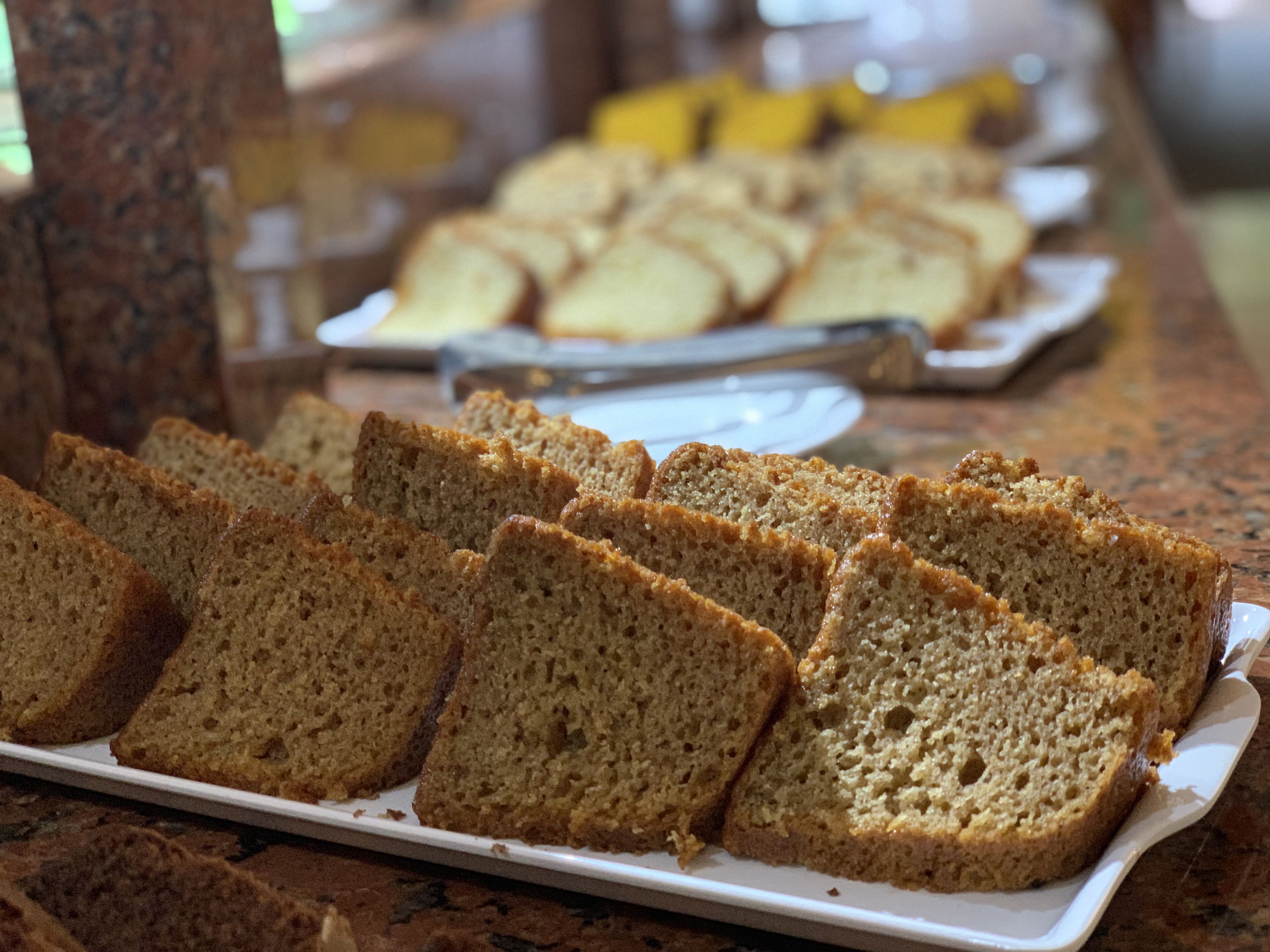 A buffet table with several slices of bread and a plate of cake.
